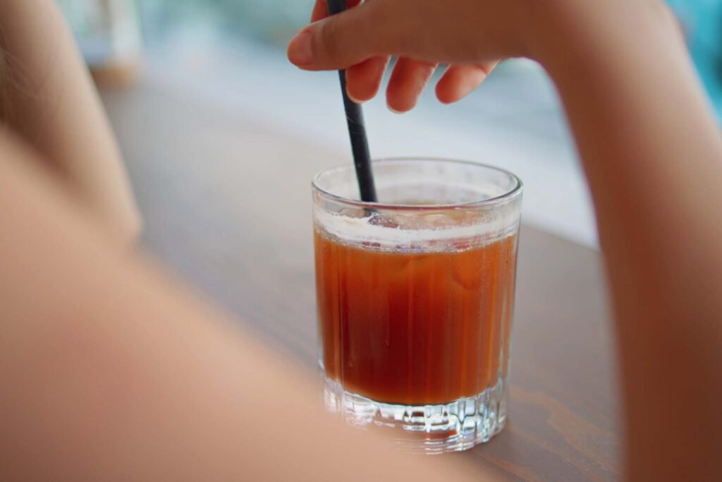unrecognizable-woman-drinking-straw-cool-cocktail-H7TP3YW.jpg